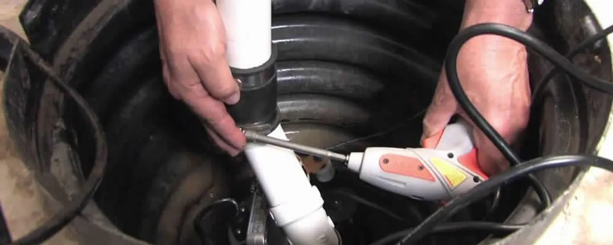 Sump pump installation technician connecting PVC discharge piping in Greensboro, NC